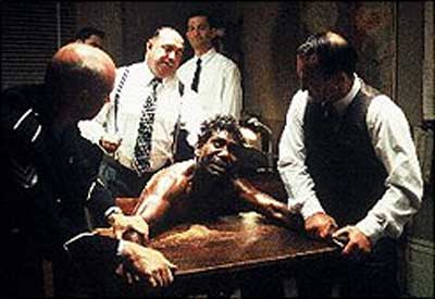 The cops try to beat a confession out of Max, I think. Hardly the clearest photo. Black and White image